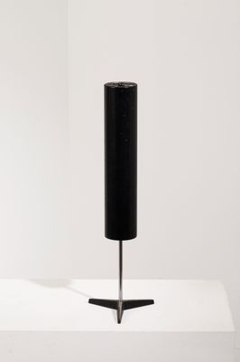 une image représentant une lampe noire posée sur une table blanche