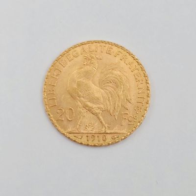 une pièce d'or représentant un coq sur un fond blanc