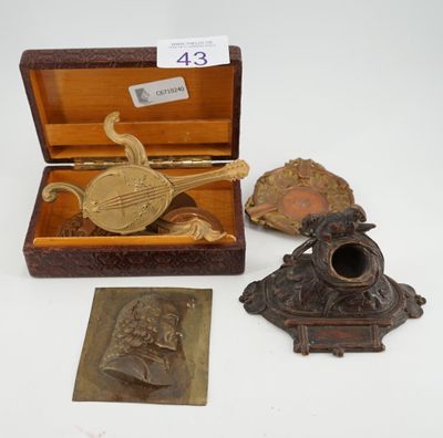 Plusieurs objets anciens en laiton sont exposés sur une surface blanche