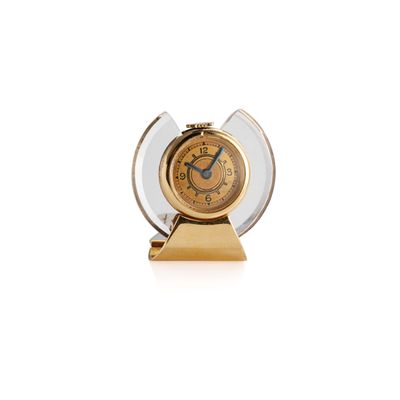 a clock that is sitting on a stand on a white surface