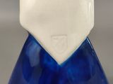 a blue and white vase with a white hat on it