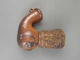 a small wooden pipe with a handle on a table