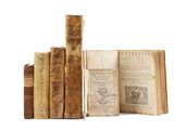 several old books sitting on top of each other on a white surface