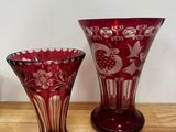 deux vases rouges posés l'un à côté de l'autre sur une table