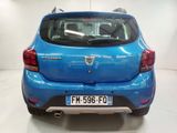 the rear end of a blue car parked in a white room