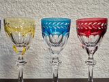 several different colored wine glasses lined up on a table