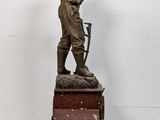 statue of a man holding a child on top of a wooden box