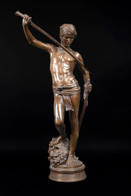 une statue en bronze représentant un homme tenant une lance, sur fond noir
