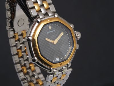 une montre-bracelet en argent et en or avec un cadran noir