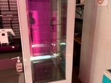 un réfrigérateur avec une porte vitrée, placé dans un coin de la pièce