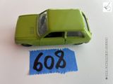 une petite voiture verte posée sur une feuille de papier