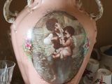 a pink vase with a picture on it sitting on a shelf