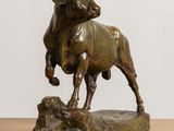 bronze statue of a bull on a rock on a table