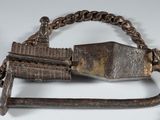 a metal object with a chain around it on a white surface