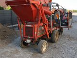 an image of a red dump truck parked in the dirt