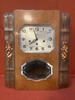 une horloge en bois posée sur une surface rouge