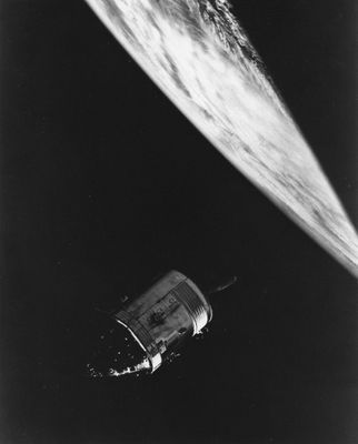 une photo en noir et blanc d'une station spatiale avec un satellite en arrière-plan