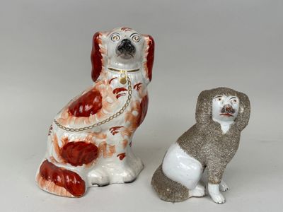 deux figurines de chiens assis l'une à côté de l'autre sur une surface blanche