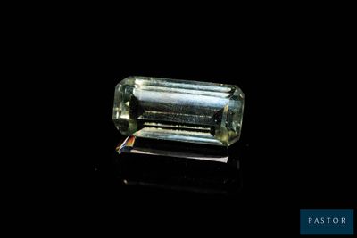 a close up of a green tourmaline stone on a black surface