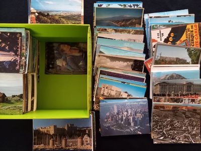 beaucoup de cartes postales dans une boîte verte posée sur une table