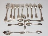 a lot of spoons and forks laid out on a table