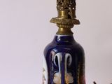 a blue and gold lamp with a bell on it