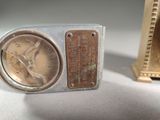 a small clock sitting next to a small clock on a table