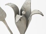 a metal sculpture of a flower with leaves on it