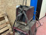 une photo montrant une machine à souder posée à côté d'une pile de palettes
