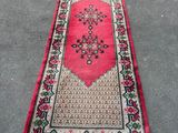 un tapis rouge orné d'un motif floral, posé à même le sol