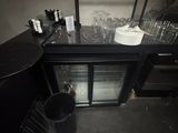 a black counter with a glass door and a wine cooler