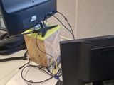 a computer monitor sitting on top of a desk next to a laptop