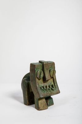 une image représentant une petite sculpture en bronze représentant un visage, sur fond blanc