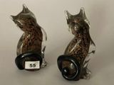 deux figurines de chats assis l'un à côté de l'autre