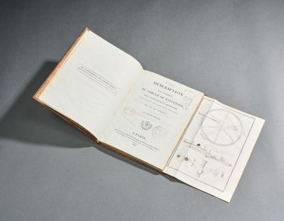 un livre ouvert, sur lequel figure une carte, posé sur une table