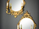 deux miroirs dorés, flanqués de bougies de chaque côté, accrochés au mur