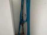 a blue hose that is next to a white wall