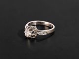 a close up of a diamond ring on a black surface