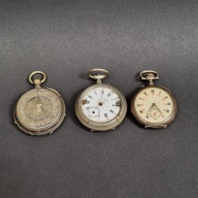 trois types différents de montres de poche posées sur une table