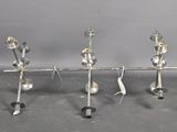 three candles that are sitting on a metal stand