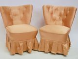 pair of orange velvet chairs with ruffled skirt