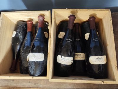 three bottles of wine in a wooden box on a table