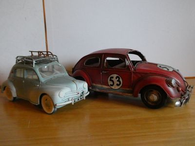 two toy cars sitting next to each other on a table