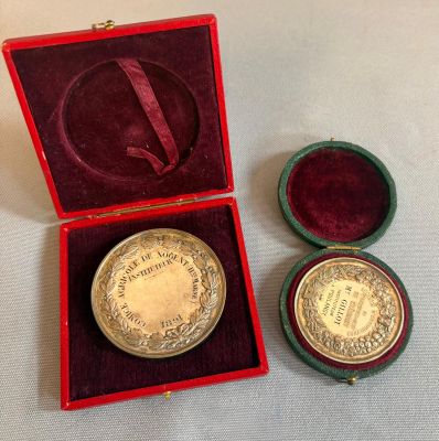 l'image d'une médaille d'or dans un coffret rouge posé sur un fond blanc
