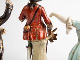 three figurines of people dressed in historical clothing and hats