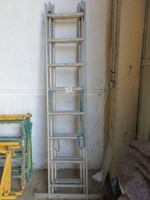 une échelle appuyée contre un mur, à côté d'une chaise