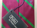 purple and green striped neck tie with a black tag on it