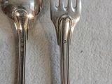 deux cuillères et une fourchette en argent sur une table