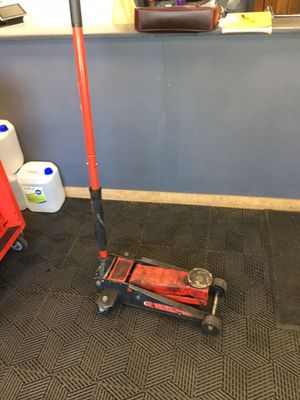 a red scooter sitting on the floor next to a red fire hydrant