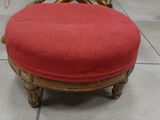 a red ottoman sitting on a tile floor in a room